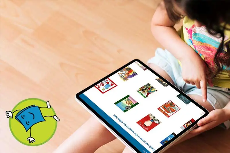 child using tumblebooks on a tablet while sitting on the floor